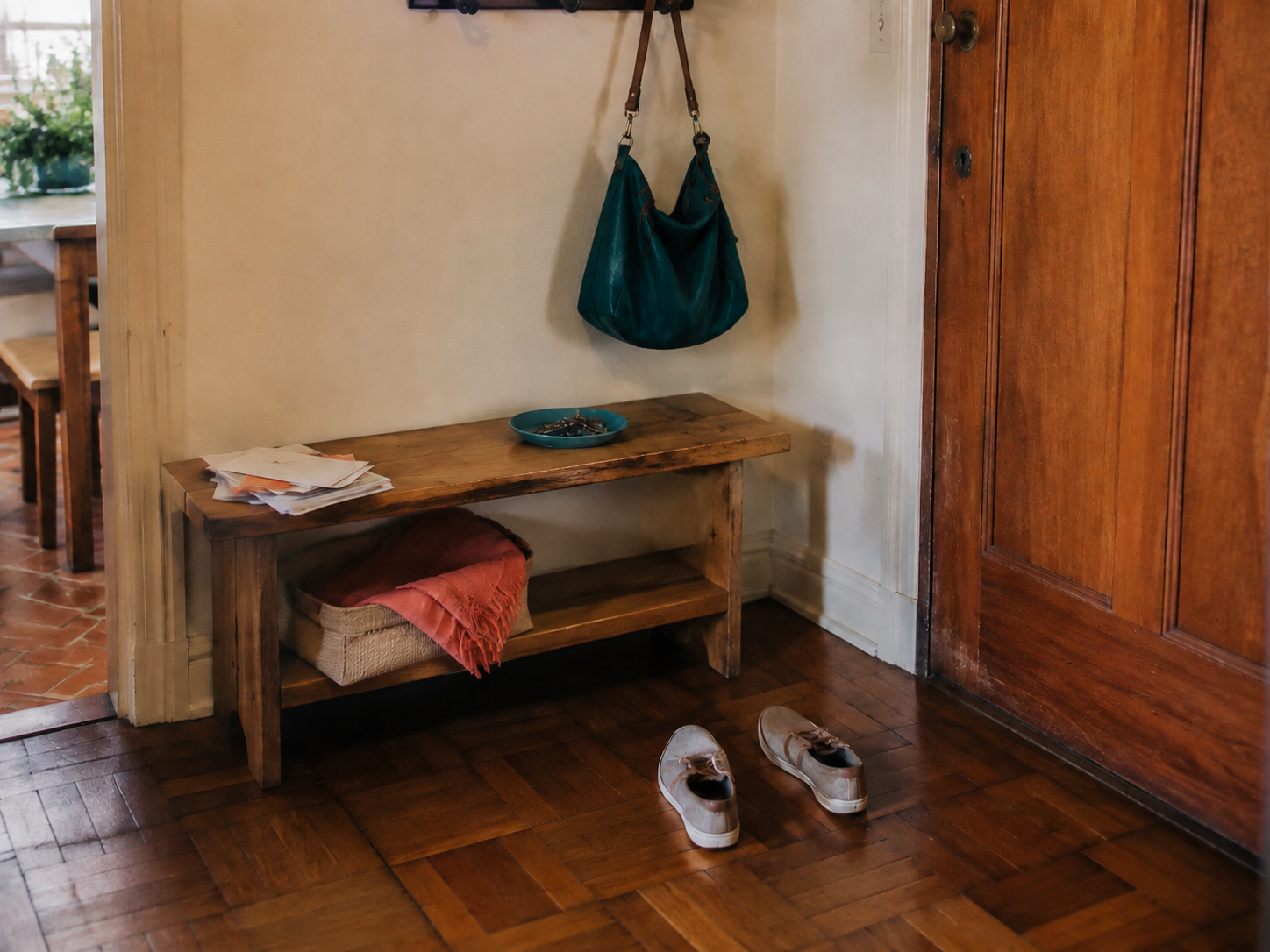 Entrada de apartamento real com banco, bolsa, chaves, correspondências e cesto